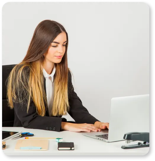 A woman in a business suit diligently working on a laptop to improve online presence with professional content writing services.